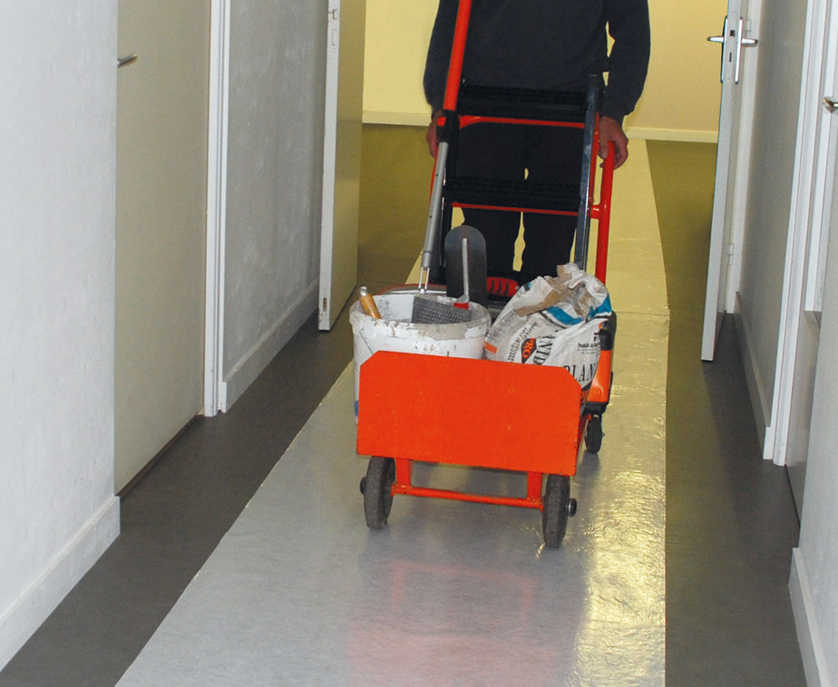 Une personne utilisant un chariot sur la bâche de protection auto adhésive
