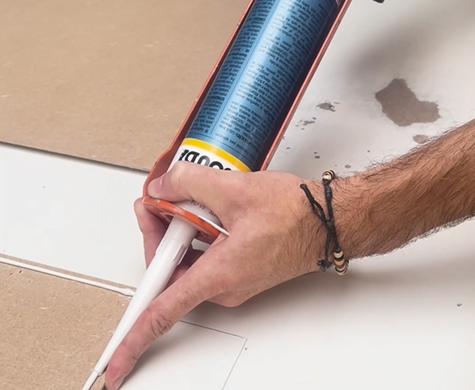 Utilisation du mastic-colle universel avec un pistolet à cartouche pour le collage d'un panneau d'habillage de portes