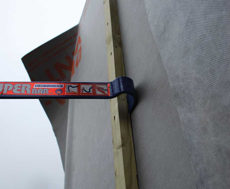 Utilisation du pied de biche sur une planche en bois contre un mur