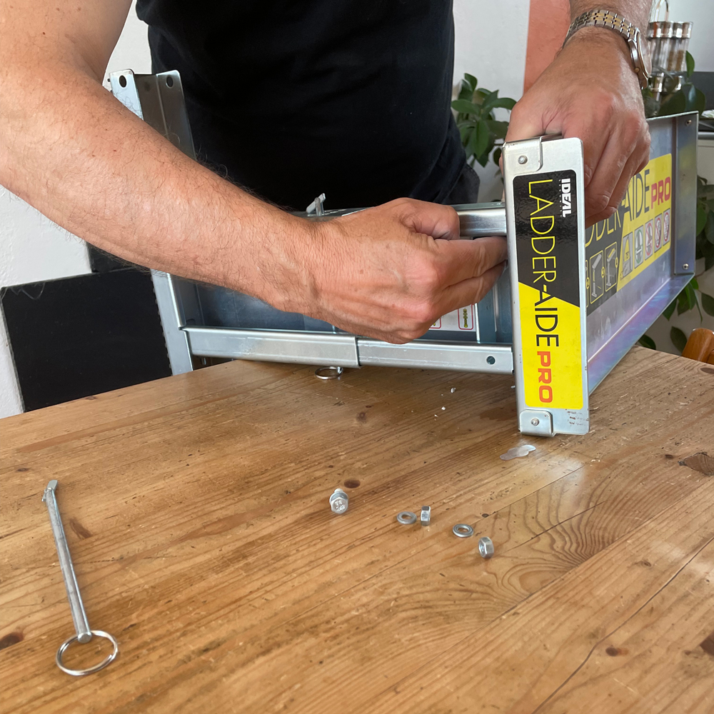 une personne entrain d'assembler le taquet d'escalier Ladder Aide Pro